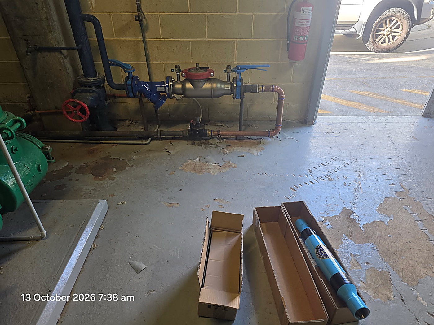 Pump room supply line and backflow preventer at East Perth Campus with the PW200 unpacked on the floor, 13 October 2026