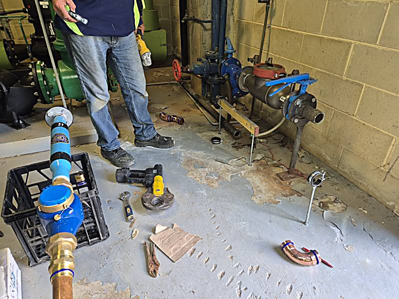 Installer fitting the PW200 and new meter to the supply line